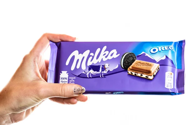 Milka alpine Milchschokolade. Studioaufnahme, Frau hält eine Milka in der Hand — Stockfoto