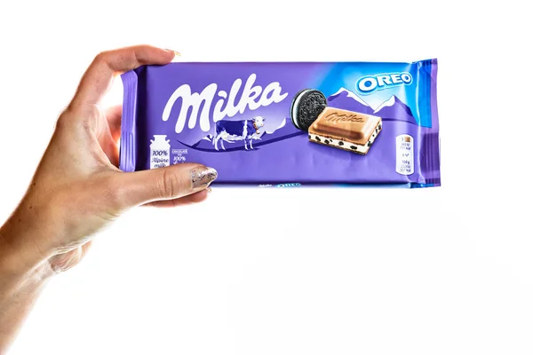 Milka alpine Milchschokolade. Studioaufnahme, Frau hält eine Milka in der Hand — Stockfoto