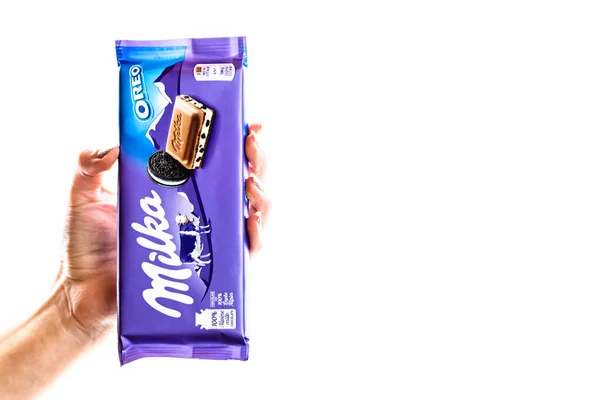 Milka alpine Milchschokolade. Studioaufnahme, Frau hält eine Milka in der Hand — Stockfoto