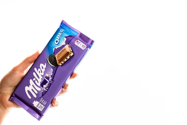 Milka alpine Milchschokolade. Studioaufnahme, Frau hält eine Milka in der Hand — Stockfoto