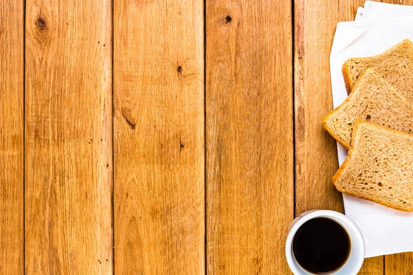 Cup of coffee and wholegrain toast over wooden table, top view, — Stock Photo, Image