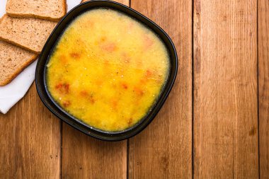 Ekşi kremalı tavuk çorbası, beyaz peçetede kepekli tost.