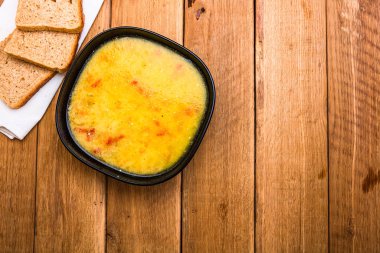 Ekşi kremalı tavuk çorbası, beyaz peçetede kepekli tost.