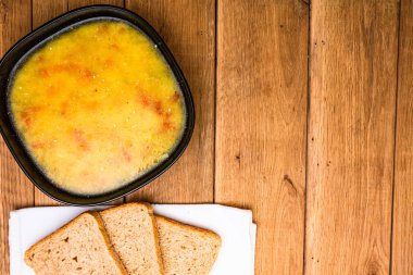 Ekşi kremalı tavuk çorbası, beyaz peçetede kepekli tost.
