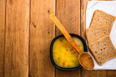 Ekşi kremalı tavuk çorbası, beyaz peçetede kepekli tost.