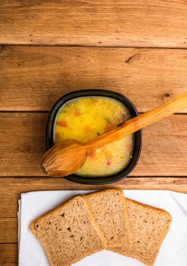 Ekşi kremalı tavuk çorbası, beyaz peçetede kepekli tost.