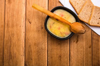 Ekşi kremalı tavuk çorbası, beyaz peçetede kepekli tost.