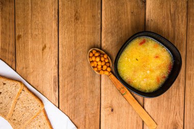 Ekşi kremalı tavuk çorbası, beyaz peçetede kepekli tost.