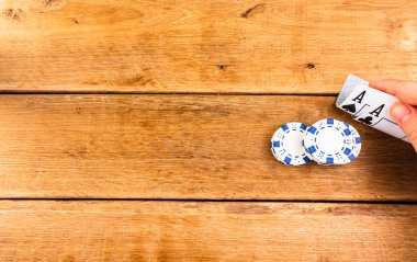 Tahta arka planda aslar, poker fişleri, krupiye, kumar