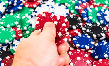 Hand holding and giving poker chips poker chips background. Casi