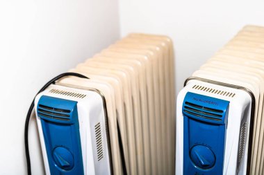 Beyaz arka planda fişi olan petrolün üzerine beyaz elektrikli ısıtıcı
