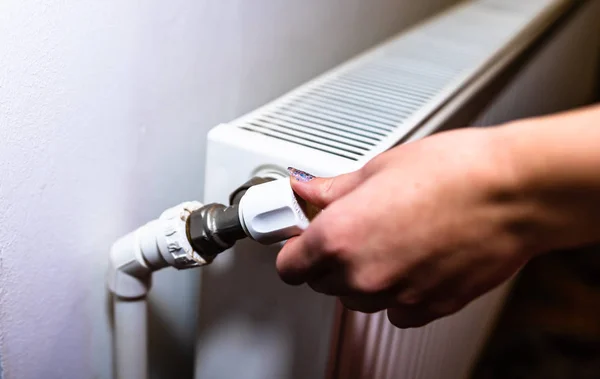 Close up of hand adjusting heating thermostat. Central heating c — Stock Photo, Image