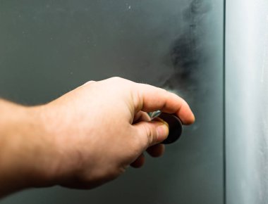 El, çim kapıyı açıyor. Bir adamın eli kapalıyken bir kaka açılır