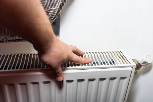 Hand adjusting thermostat valve of heating radiator in a room. C — Stock Photo, Image