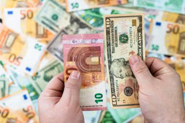 El ele tutuşan para, banknotların arkasında izole edilmiş. Euro ve Biz