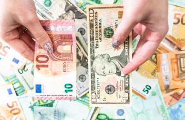 El ele tutuşan para, banknotların arkasında izole edilmiş. Euro ve Biz