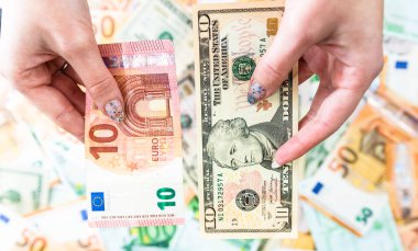 El ele tutuşan para, banknotların arkasında izole edilmiş. Euro ve Biz