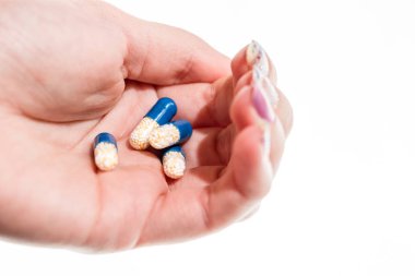 Elinde antibiyotik kapsülleri ya da ağrı kesiciler var.