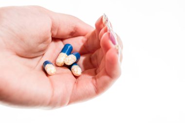 Elinde antibiyotik kapsülleri ya da ağrı kesiciler var.