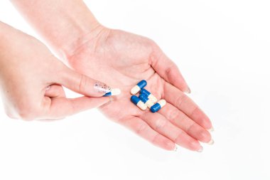 Elinde antibiyotik kapsülleri ya da ağrı kesiciler var.