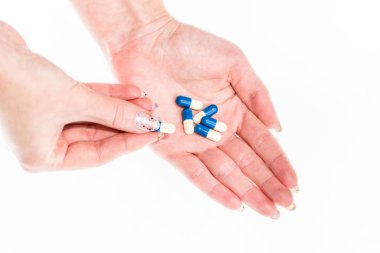 Elinde antibiyotik kapsülleri ya da ağrı kesiciler var.