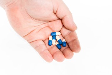 Elinde antibiyotik kapsülleri ya da ağrı kesiciler var.