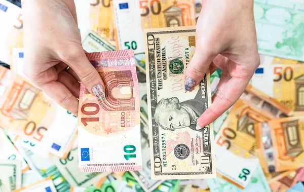Mână care deține bani izolați pe fundalul bancnotelor. EURO și SUA — Fotografie, imagine de stoc