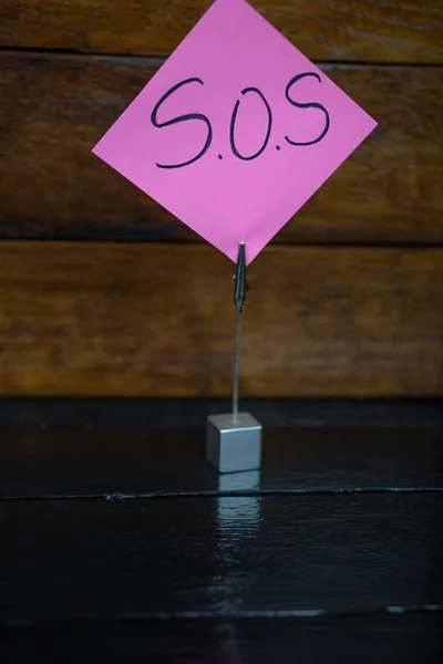Suporte de memorando quadrado com lembrete de post de memorando. Escrevendo SOS no papel — Fotografia de Stock