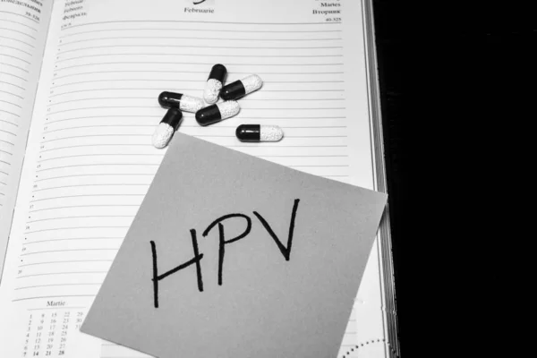 Escrevendo HPV em memo post lembrete e medicamentos, comprimidos. Escrever — Fotografia de Stock
