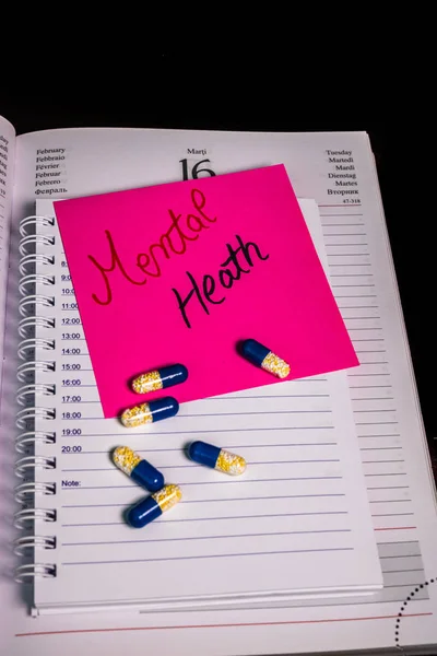 Escrevendo Saúde Mental em memo post lembrete e medicamentos, pílula — Fotografia de Stock