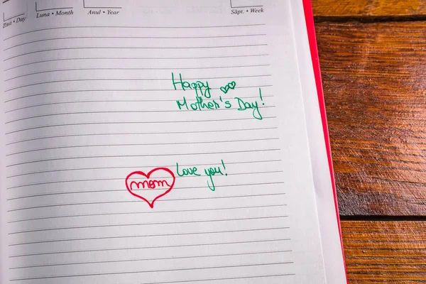 Mother`s day concept. Writing text for mother on personal agenda