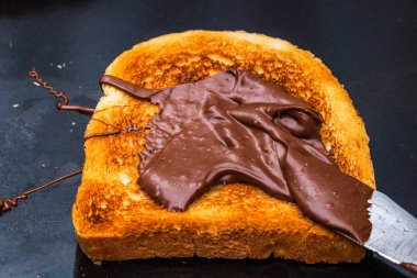 Siyah arka planda çikolata kremalı tost..