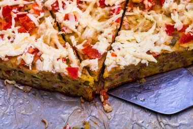 Yumurtalı, etli, sebzeli ve peynirli taze pişmiş turta dilimleri.