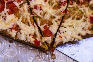 Yumurtalı, etli, sebzeli ve peynirli taze pişmiş turta dilimleri.
