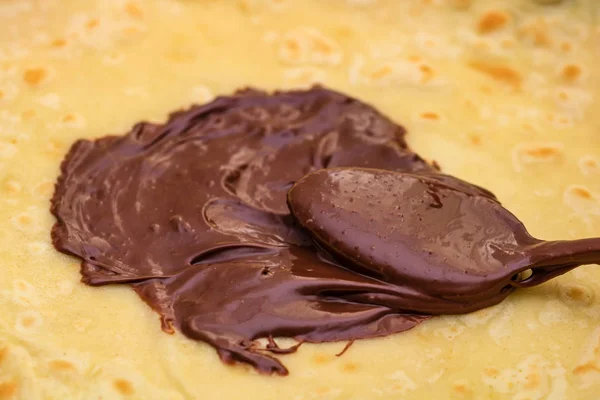 Łyżka z czekoladą i kremem z orzechów laskowych, izolowane na domowej roboty pa — Zdjęcie stockowe