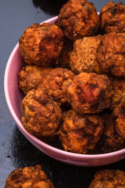Pink bowl with fried meatballs with spices. Homemade food. — Stock Photo, Image