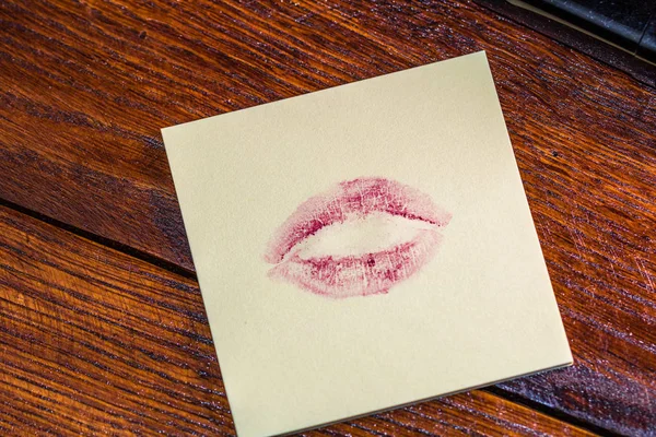 Valentine`s day concept. Lipstick kiss on memo post reminder.