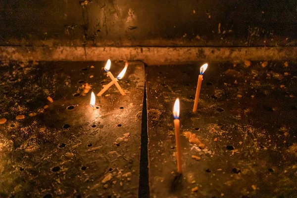 Iluminando velas em uma igreja ortodoxa. Fechar . — Fotografia de Stock