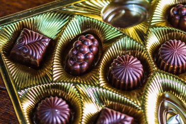 Altın bir kutuda çeşitli çikolatalı pralinler. Kapat şunu.