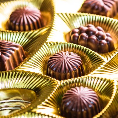 Altın bir kutuda çeşitli çikolatalı pralinler. Kapat şunu.