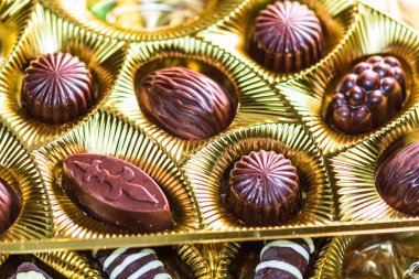 Altın bir kutuda çeşitli çikolatalı pralinler. Kapat şunu.