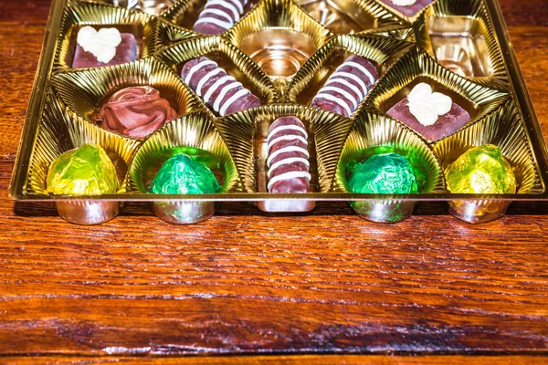 Vielfalt köstlicher Schokoladenpralinen in einer goldenen Schachtel. schließen u — Stockfoto