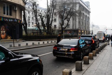 Radiss 'in önünde turist bekleyen siyah arabalar ve özel arabalar.