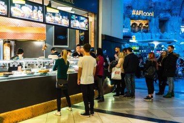 Alışverişçiler indirim ve indirim sezonunda alışveriş merkezini ziyaret ederler.