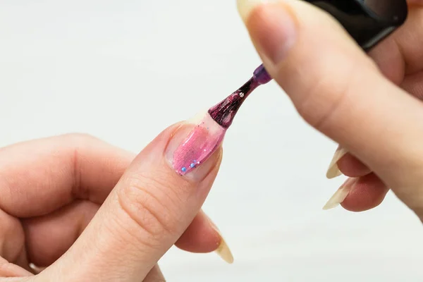 Manos femeninas haciendo manicura, esmalte de uñas en color oro brillo o —  Fotos de Stock