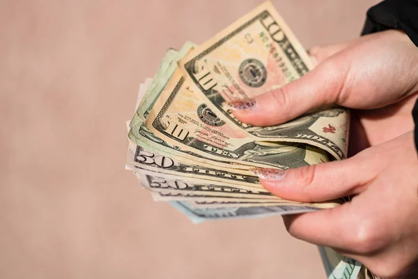 Woman counting money, counting dollars close up.