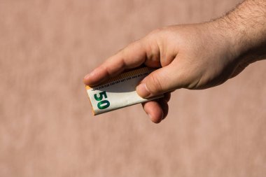 Adam eli rüşvet ya da bahşiş gibi para veriyor. Avro banknotunu elinde tutmak