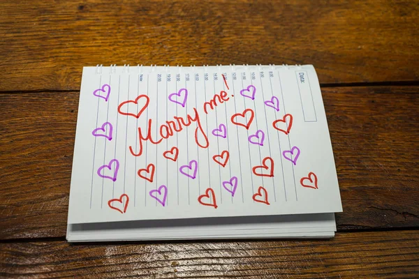 Marry me, writing love text on paper, lovely message. Text on sp — Stockfoto