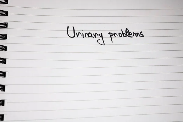 Urinary problems handwriting  text on paper, on office agenda. C — Stockfoto