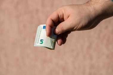 Adam eli rüşvet ya da bahşiş gibi para veriyor. Avro banknotunu elinde tutmak